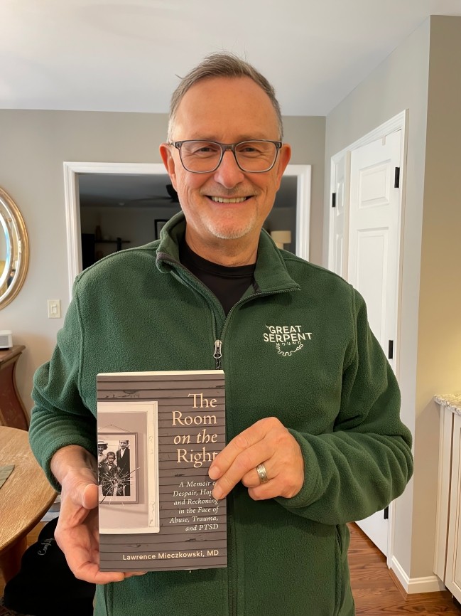 Dr. Lawrence “Mitch” Mieczkowski holding his memoir The Room on the Right